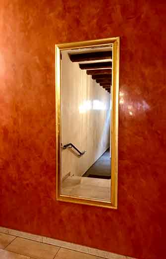 mur rouge brillant avec cadre en or miroir